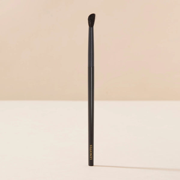 Brush Me Blending Angled Brush No. 103 by Lenoites, featuring a sleek black handle and a soft angled brush head, displayed against a soft beige background.