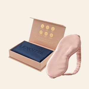 Pillowcase and Sleep Mask in Mulberry Silk by Lenoites featuring a pink silk sleep mask and a blue mulberry silk pillowcase presented in an open blush pink box against a soft light background.