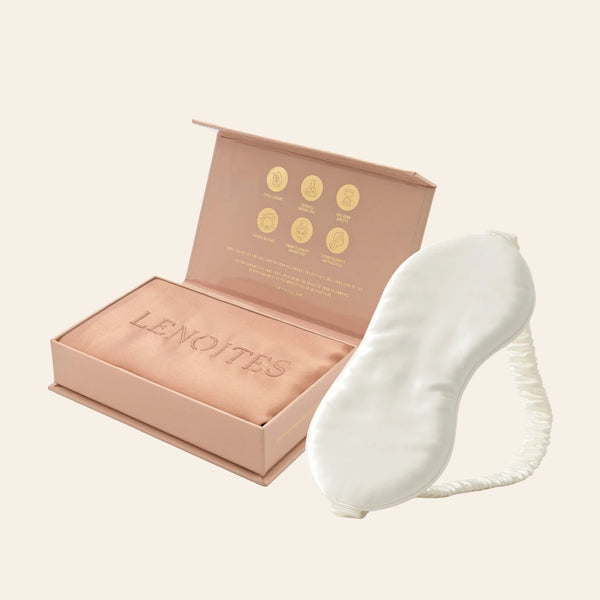 Pillowcase and Sleep Mask in Mulberry Silk by Lenoites featuring a white silk sleep mask and a rosegold mulberry silk pillowcase presented in an open blush pink box against a soft light background.