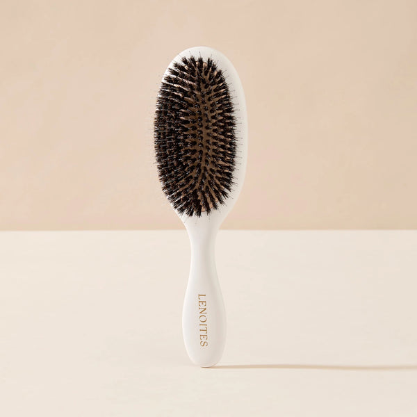 Wild Boar Hair Brush in White by Lenoites, featuring a sleek handle and bristles, displayed against a soft beige background.