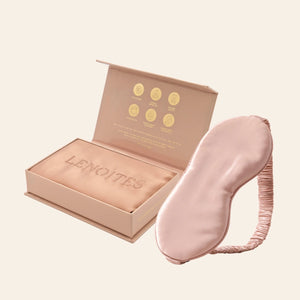 Pillowcase and Sleep Mask in Mulberry Silk by Lenoites featuring a pink silk sleep mask and a rosegold mulberry silk pillowcase presented in an open blush pink box against a soft light background.